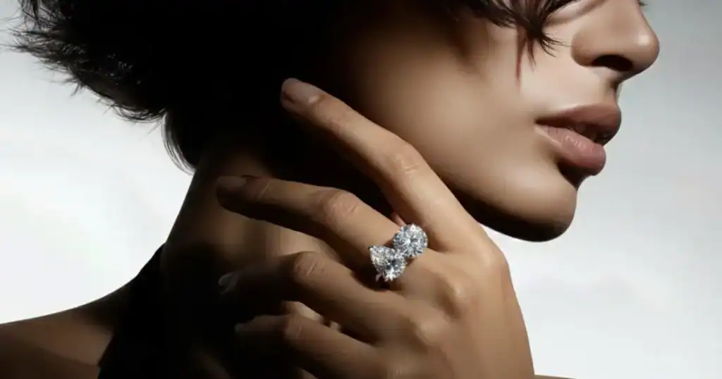 toi et moi ring with pear and round cut lab-grown diamonds on woman's hand