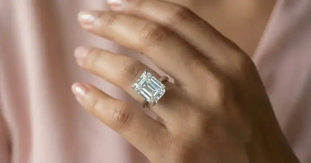 Emerald cut engagement ring with lab-grown diamond in 18K white gold on woman's hand