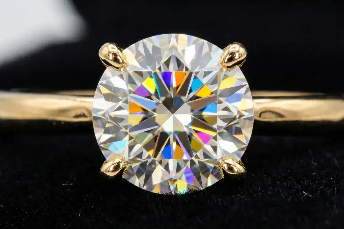 Round brilliant cut labgrown diamond showing fire and rainbow light dispersion in 18K gold setting