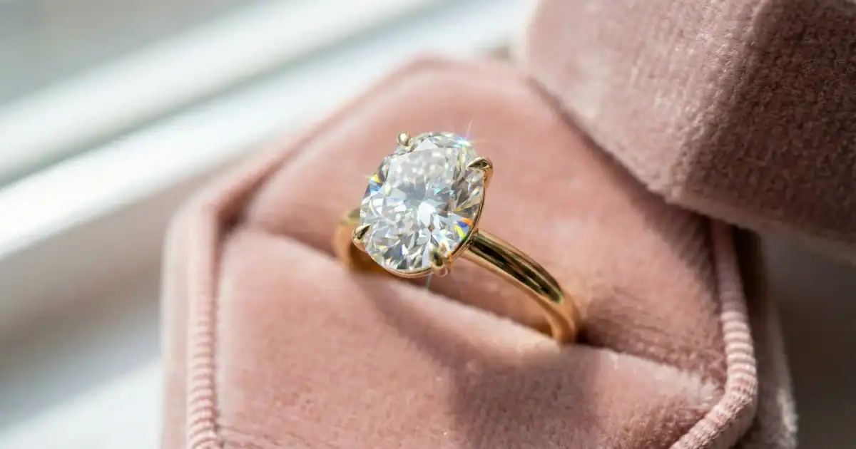 Solitaire ring price India featuring oval lab grown diamond engagement ring in 18K yellow gold on pink velvet box